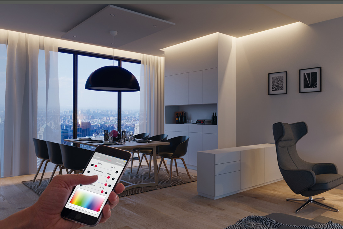 Imagem de sala de estar e jantar com iluminação led e mão segurando celular acionando as luzes de led.